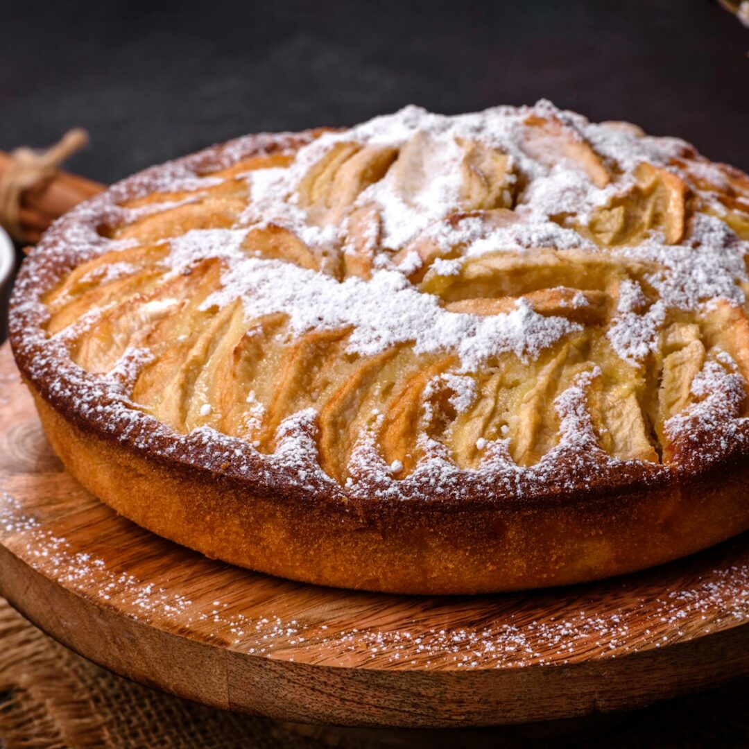 Apple pie with fresh fruits on a wooden table