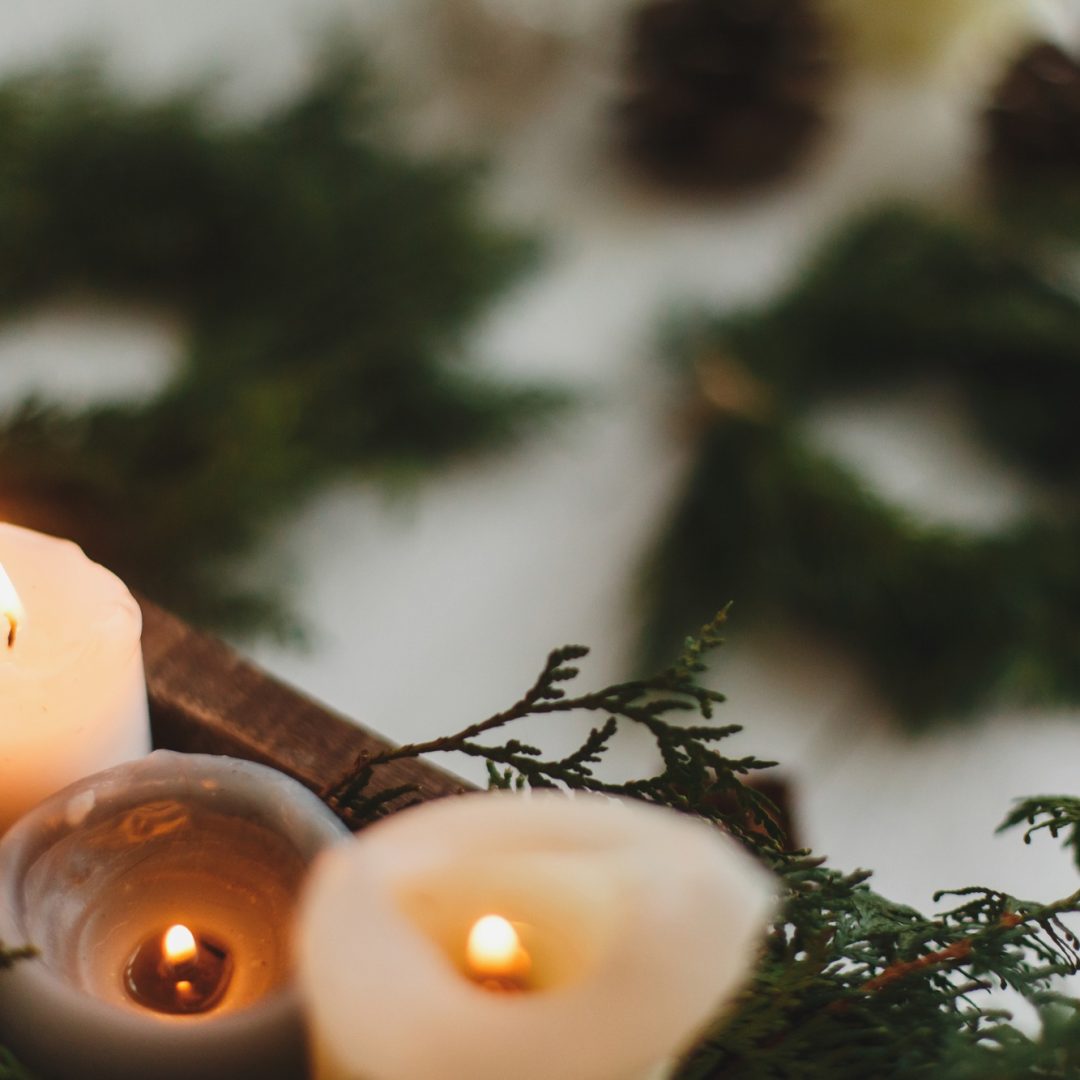 Burning candles on rustic background with christmas wreath, cozy winter advent