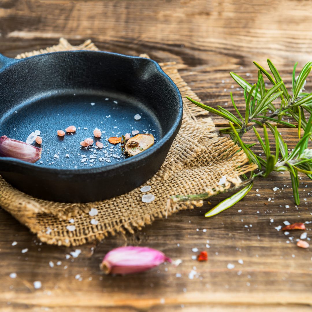 Cast-iron Frying Pan with  Spices on Rustic Wooden Background