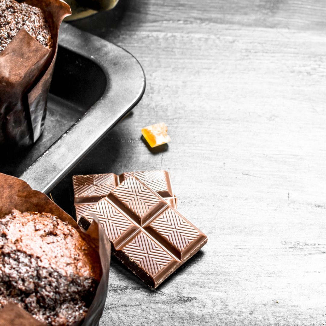 Chocolate muffins with chunks of chocolate. On the black chalkboard.