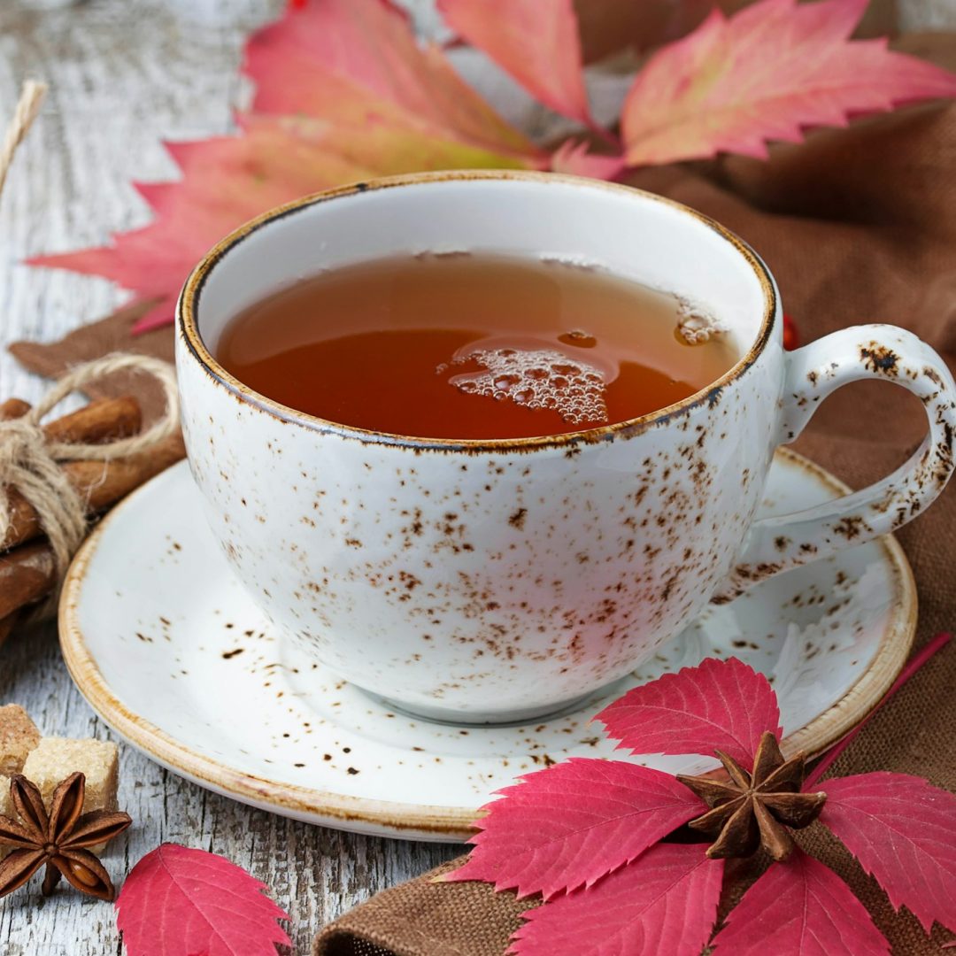 Cup of autumn tea on light wooden background